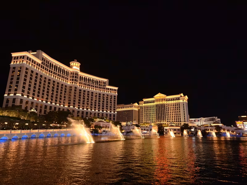 Bellagio hotel tower behind its fountain lake at dusk